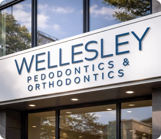 Pediatric dentist performing teeth cleaning on a child in Wellesley, MA to ensure a healthy smile and prevent cavities.